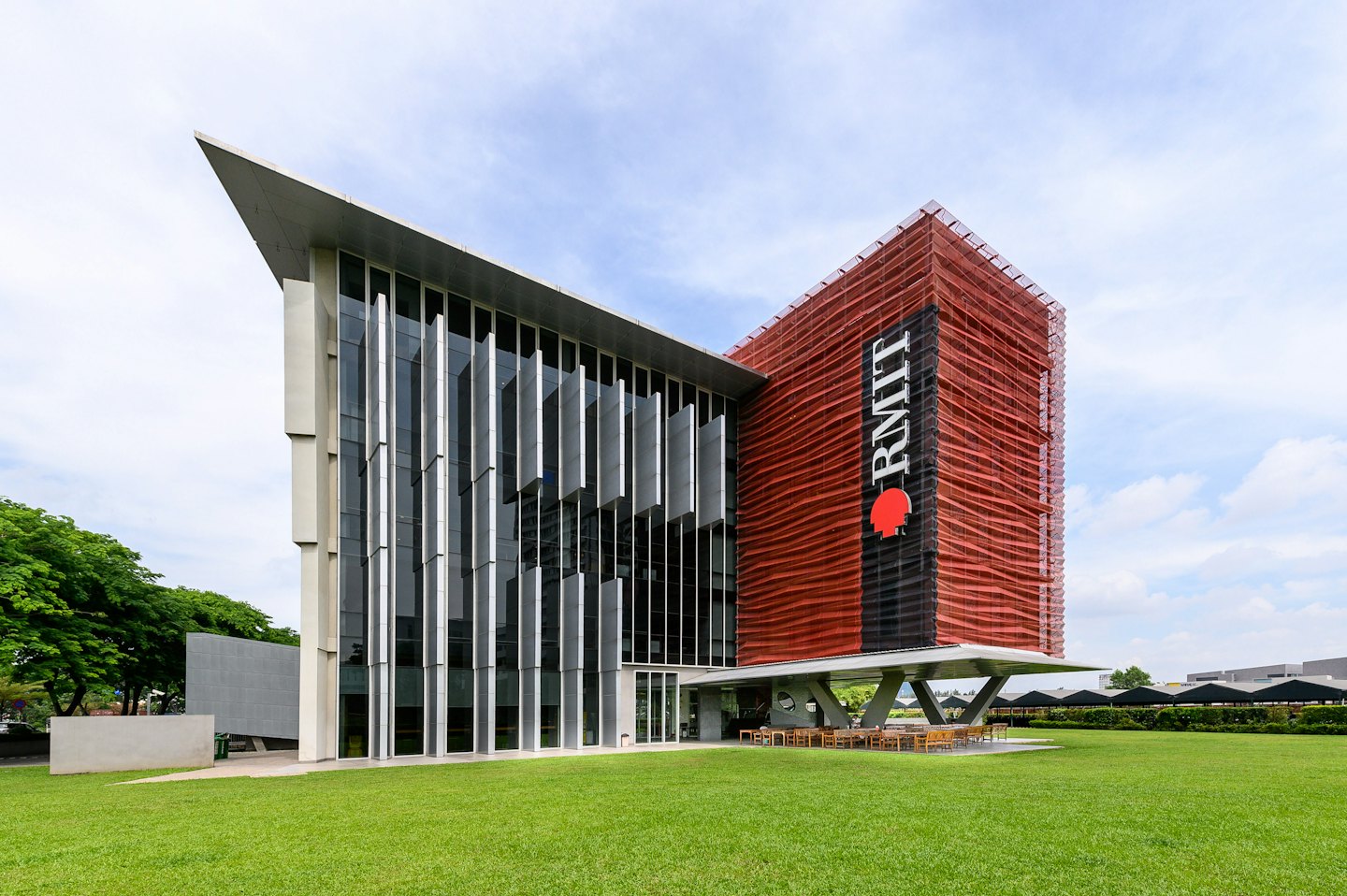 Modern university building with concrete, glass, and orange walls.